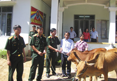 Lãnh đạo Bộ Chỉ huy Quân sự tỉnh và đại diện các đơn vị  trong Khối trao bò cho các hộ dân 