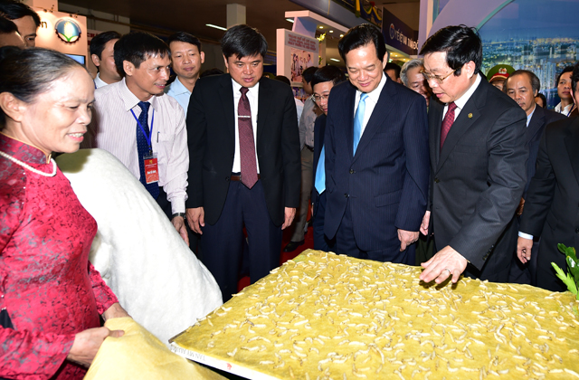 Thủ tướng Nguyễn Tấn Dũng xem sản phẩm chăn tơ tằm tự dệt. Ảnh: VGP/Nhật Bắc