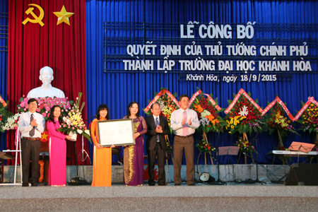 Ông Lê Thanh Quang (bìa phải) và ông Nguyễn Tấn Tuân (bìa trái) trao quyết định thành lập Trường ĐH Khánh Hòa của Thủ tướng Chính phủ cho Ban giám hiệu nhà trường. 