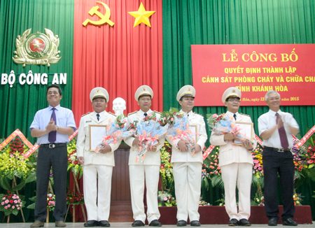 Ông Lê Thanh Quang (bìa trái) và ông Nguyễn Chiến Thắng (bìa phải) tặng hoa chúc mừng Ban Giám đốc Cảnh sát PCCC Khánh Hòa.