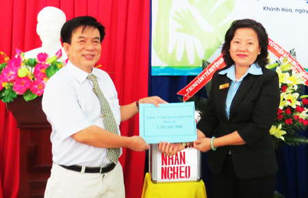 Đại diện Công ty Yến sào Khánh Hòa (phải) trao tiền ủng hộ cho bếp ăn từ thiện Bệnh viện Bệnh nhiệt đới