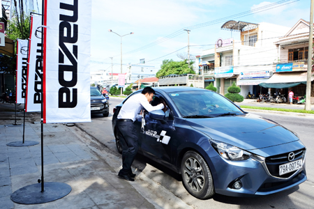 Nhân viên Showroom Mazda Nha Trang giới thiệu với khách hàng những tính năng mới của dòng ô tô Mazda 2