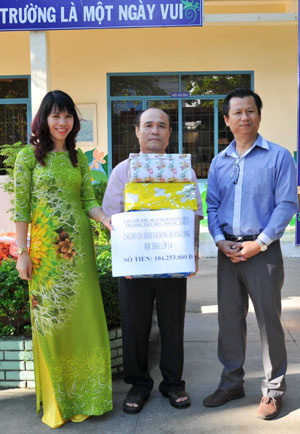 Đại diện nhà trường trao tiền và quà hỗ trợ cho gia đình em Đồng Hoàng Long.