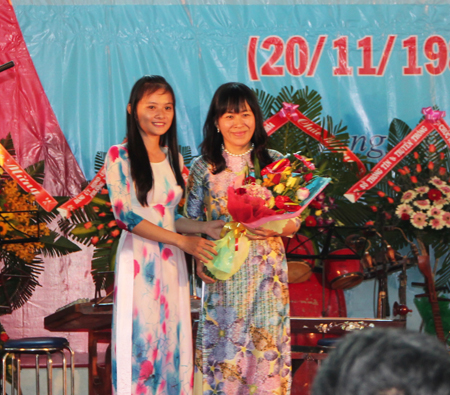 Đại diện sinh viên tặng hoa cho hiệu trưởng nhà trường. 