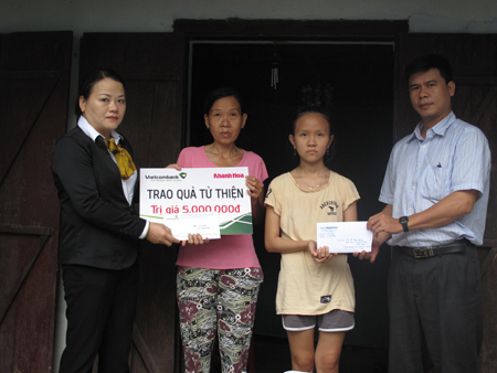 Đại diện Báo Khánh Hòa và Vietcombank Nha Trang trao tiền ủng hộ cho em Thúy