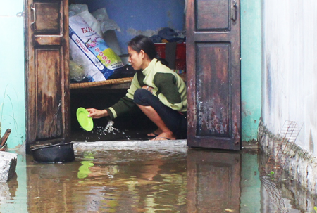 Chị Nguyễn Thị Lan tát nước từ nhà bếp ra ngoài