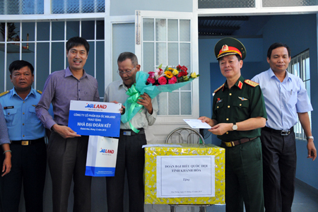 Các đại biểu trao biểu trưng nhà và tặng quà cho đại diện gia đình bà Nguyễn Thị Phương Dung