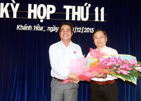 Ông Lê Thanh Quang (bên trái) tặng hoa chúc mừng ông Nguyễn Đắc Tài.