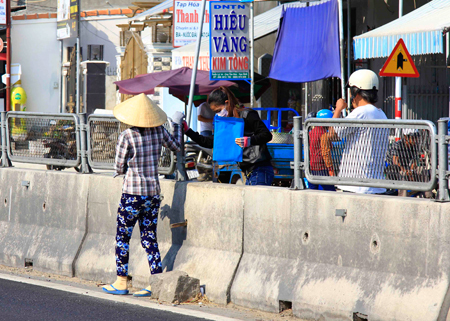 Người dân tháo tấm lưới chống lóa trên Quốc lộ 1A đoạn qua xã Vạn Lương