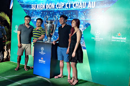 Audiences take souvenir photos with UEFA Champions League trophy.