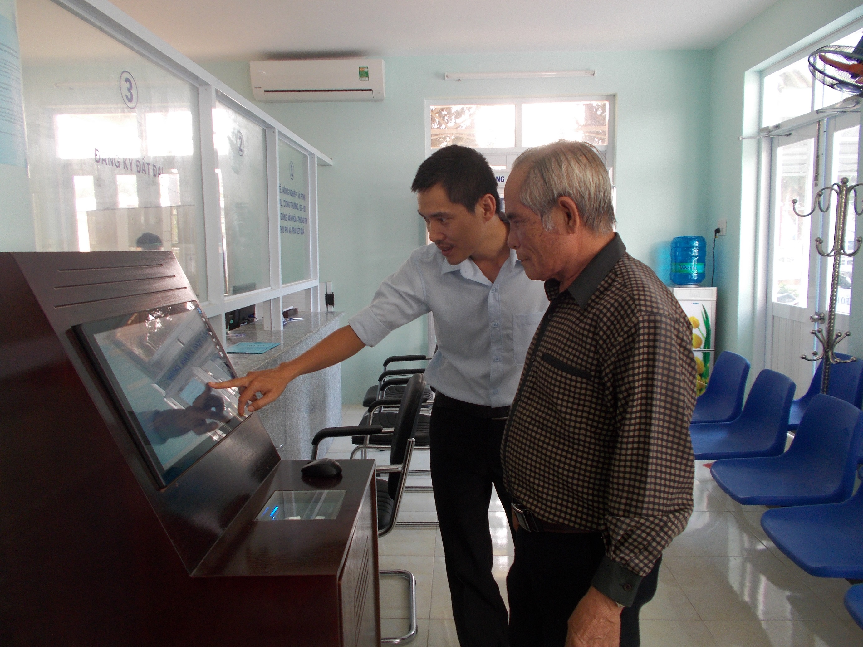 Công chức huyện hướng dẫn công dân tra cứu tiến độ giải quyết thủ tục hành chính