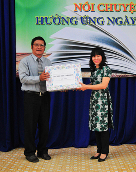 Representative of Khanh Hoa Provincial Library (left) offering books to Khanh Hoa University.