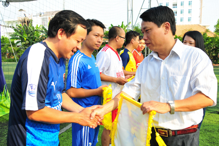 Editor-in-chief of Khanh Hoa Newspaper Tran Duy Hung giving souvenir flags to teams.