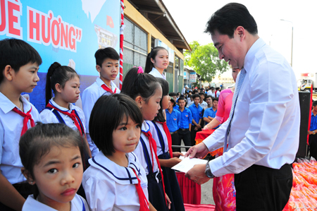 Ông Nguyễn Khắc Toàn trao học bổng cho các học sinh là con em ngư dân khó khăn.
