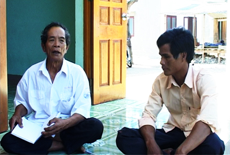 Già làng Cao Lê Dân (bên trái) vận động con cháu đóng góp kinh phí hỗ trợ xây nhà ở cho hộ khó khăn