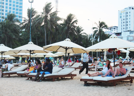 Foreign tourists having relaxing times at Nha Trang beach.