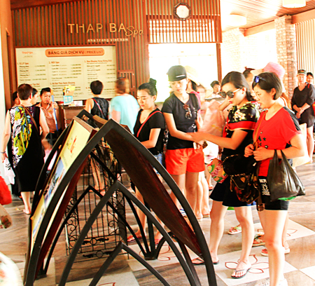 Du khách xem thông tin dịch vụ tại Trung tâm Suối khoáng nóng Tháp Bà.