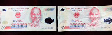 Khi vo lại, tờ tiền giả (phía dưới) đã nhăn lại bất thường so với tờ tiền thật cùng mệnh giá bên trái ảnh