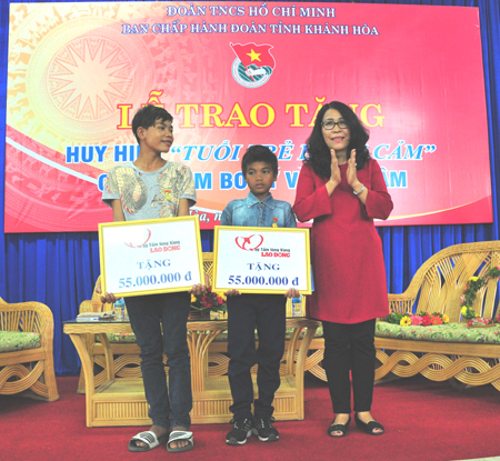 Đại diện Báo Lao động trao tiền hỗ trợ cho 2 em.