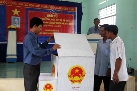 Voters witnessing ballot box checking.