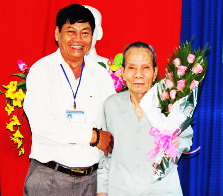 Đại diện Trung tâm Điều dưỡng và  Chăm sóc người có công tỉnh trào quà mừng thọ của Chủ tịch UBND tỉnh cho cụ ông Lê Văn Dương