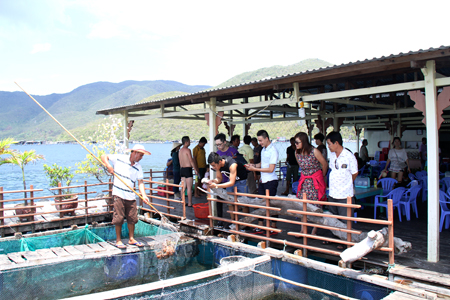 Du khách chọn mua hải sản ở một bè du lịch trên vịnh Nha Trang