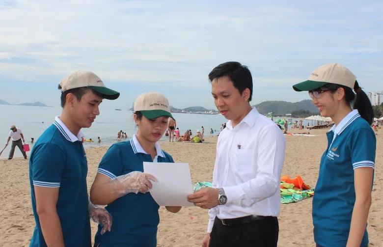 Nhân viên Khách sạn Mường Thanh Luxury Nha Trang vận động du khách cùng tham gia nhặt rác dọc bãi biển.