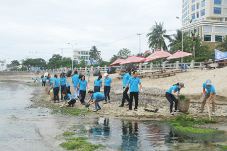 Nhân viên khách sạn Mường Thanh Grand Nha Trang đang dọn vệ sinh bờ biển. 