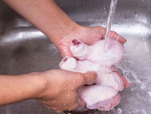 Rửa thịt gà trước khi nấu có thể làm nước bắn ra xung quanh, lây lan vi khuẩn vào tay, bếp, dụng cụ nấu bếp... Ảnh: Evoke.