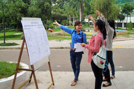 Trong khuôn viên trường, nhiều tình nguyện viên đứng chốt để hướng dẫn đường đi cho thí sinh