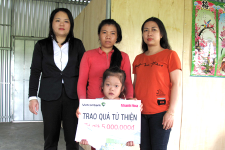 Đại diện Báo Khánh Hòa và Vietcombank Nha Trang trao tiền ủng hộ cho gia đình cháu Nguyễn Võ Lan Anh.