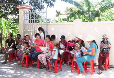 Phát tờ rơi tuyên truyền chăm sóc sức khỏe cho người dân tại xã Vạn Thạnh.