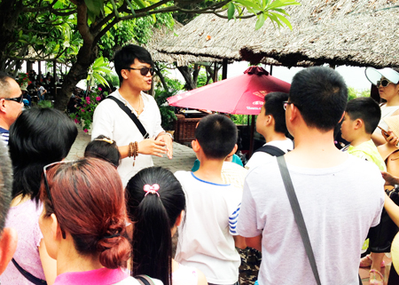 Một người Trung Quốc làm hướng dẫn viên du lịch “chui” tại danh thắng Hòn Chồng, TP. Nha Trang. (Ảnh chụp vào ngày 3-7)