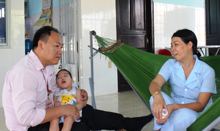 Thăm hỏi điều kiện sinh hoạt của trẻ em khuyết tật.