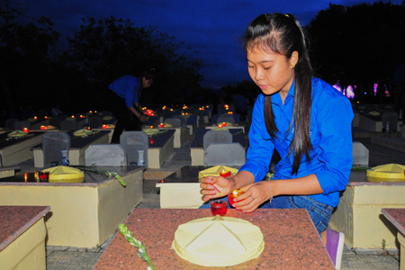Youth Union members and young people lighting candles at the martyrs’ graves.