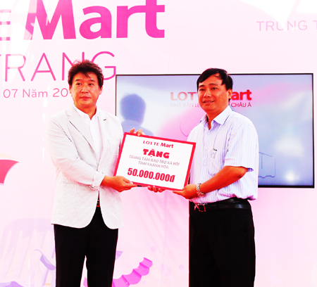 Đại diện lãnh đạo Lotte Mart (bên trái) trao tượng trưng phần quà hỗ trợ trang thiết bị cho Trung tâm Bảo trợ xã hội tỉnh tại lễ khai trương Lotte Mart Nha Trang