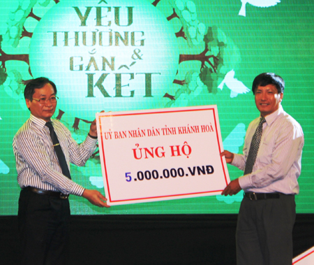 Ông Nguyễn Đắc Tài (bên phải) trao hỗ trợ của UBND tỉnh tại chương trình.