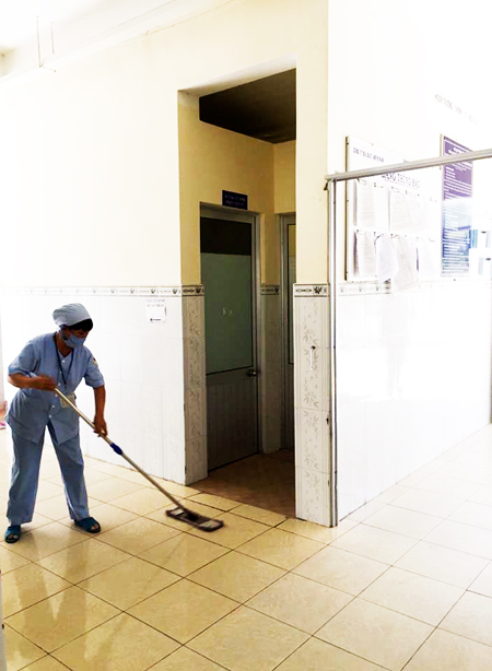 Hộ lý Bệnh viện Đa khoa khu vực Cam Ranh đang dọn nhà vệ sinh