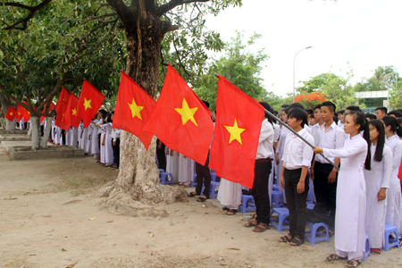 Các em học sinh Trường THPT thực hiện nghi thức chào cờ.