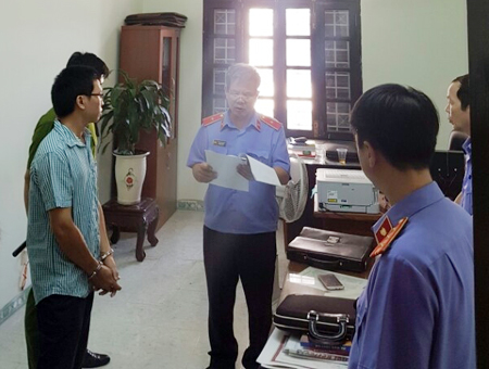 Cơ quan điều tra tống đạt quyết định bắt tạm giam Kiểm sát viên Lê Ngọc Phổ. (Ảnh: A.X)