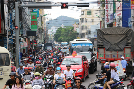 Tuy đèn tín hiệu giao thông đã chuyển sang màu đỏ nhưng các xe vẫn chen nhau di chuyển