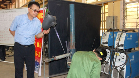 Chuyên gia huấn luyện nghề hàn người Hàn Quốc đang theo dõi thao tác hàn của thí sinh