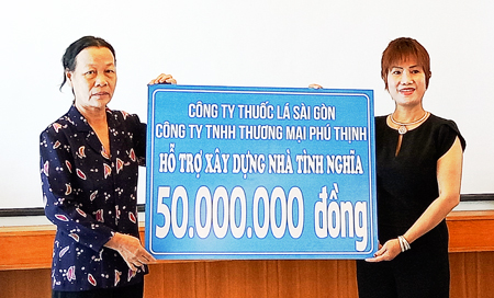 Đại diện Công ty TNHH Thương mại Phú Thịnh trao kinh phí cho đại diện một gia đình