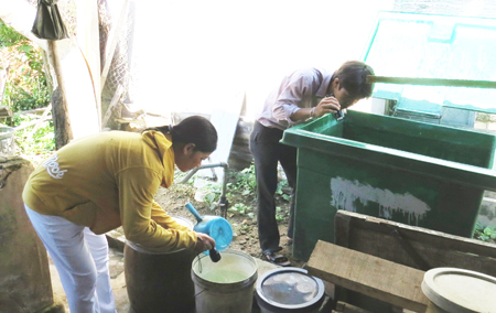 Nhân viên y tế thôn bản kết hợp với cán bộ y tế kiểm tra lăng quăng tại một hộ ở huyện Khánh Vĩnh