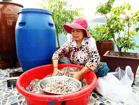 Bà Nguyễn Thị Kéo làm nước mắm tại nhà cho gia đình bà Lê Thị Thành