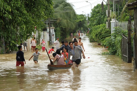 Người dân xã Vĩnh Phương dùng xuồng để chở người qua vùng ngập nước. 