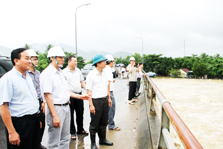 Đồng chí Lê Đức Vinh (thứ ba từ trái qua) kiểm tra tình hình mực nước sông Cái ở vị trí cầu Vĩnh Phương