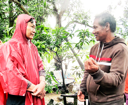 Đồng chí Nguyễn Đắc Tài (bên trái) trao đổi với người dân sinh sống ven suối tại xã Cầu Bà, Khánh Vĩnh