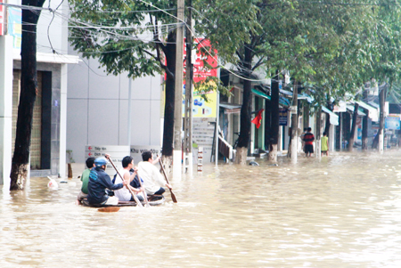 Người dân dùng xuồng di chuyển trên đường 23-10