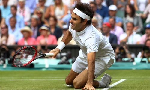 Federer trượt ngã trong trận thua Raonic tại Wimbledon. Ảnh: Reuters.